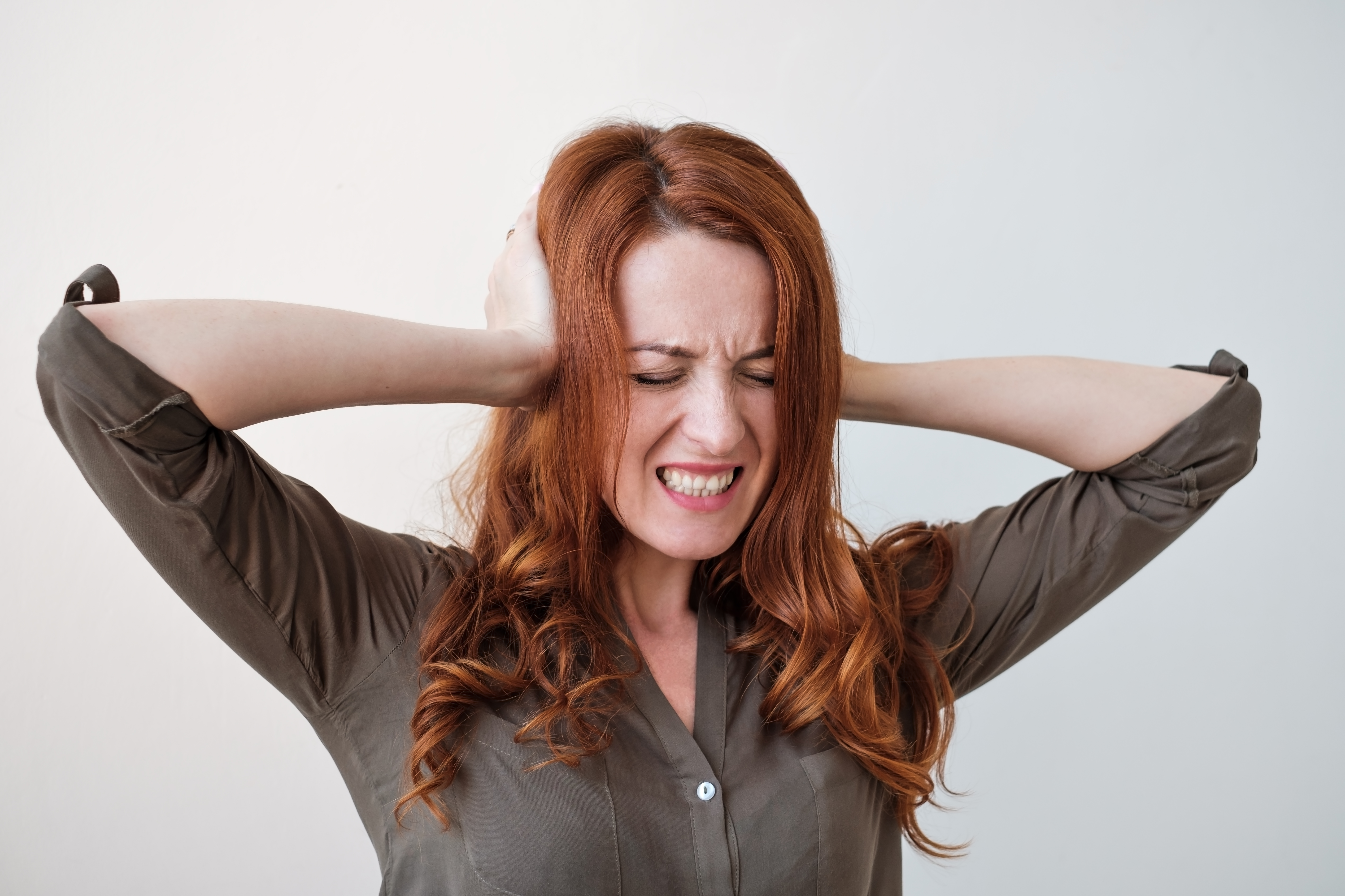 long haired beautiful young brunette woman hold head in pain